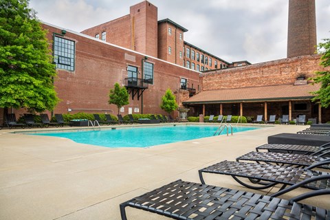 A pool area with a brick building in the background.