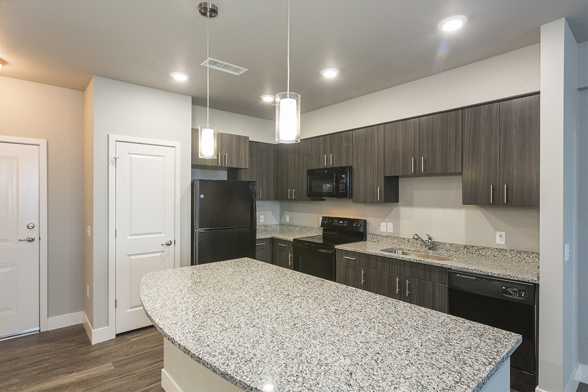 a kitchen with granite counter tops and black appliances