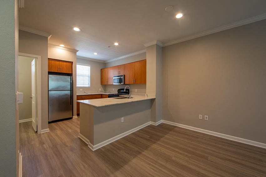 an empty kitchen with a refrigerator and a sink