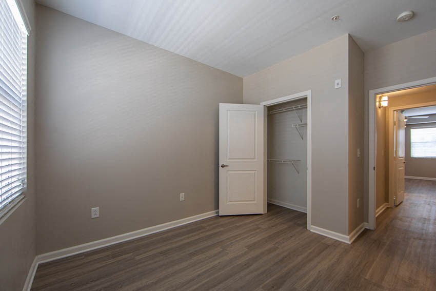 an empty room with a door to a closet and a window