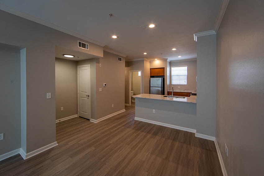 an empty living room and kitchen with a sink and a counter