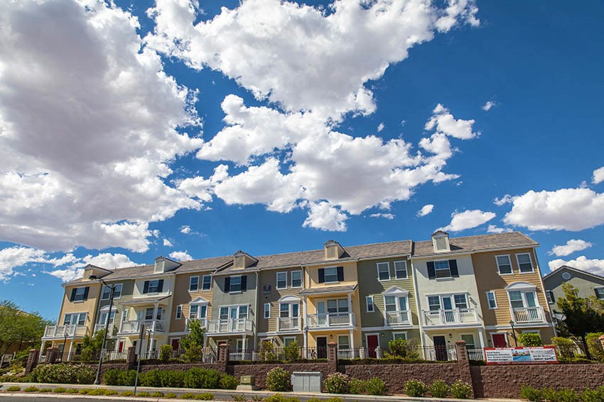 a large apartment building with a cloudy sky in the background