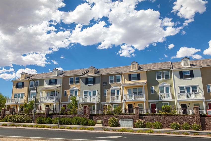 a row of apartment buildings on the side of a street