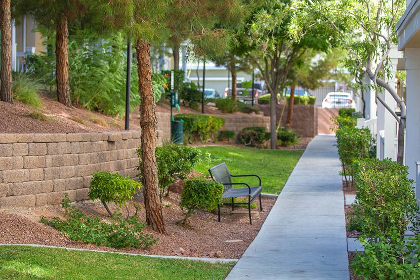 a bench in a park next to a sidewalk