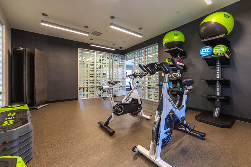 a gym with exercise bikes and helmets in a room
