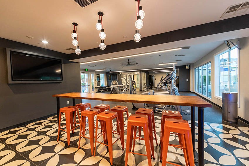 a bar with bar stools and chairs in a room with a tv