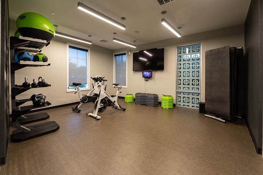 a gym with weights and a tv on the wall