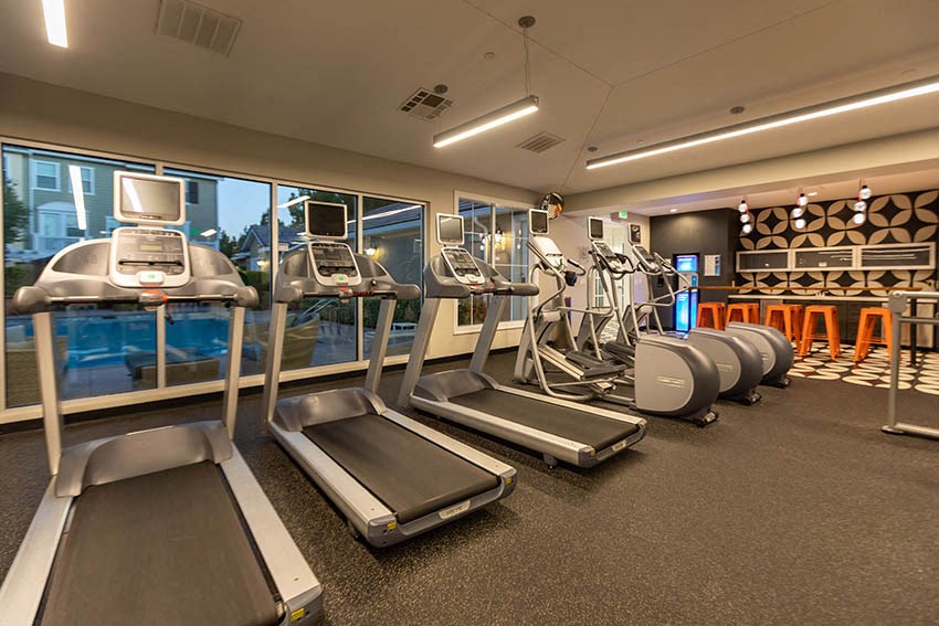 a gym with cardio equipment and a view of a pool