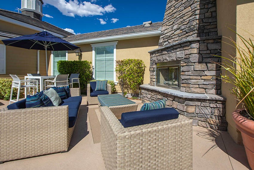 a patio with furniture and a stone fireplace