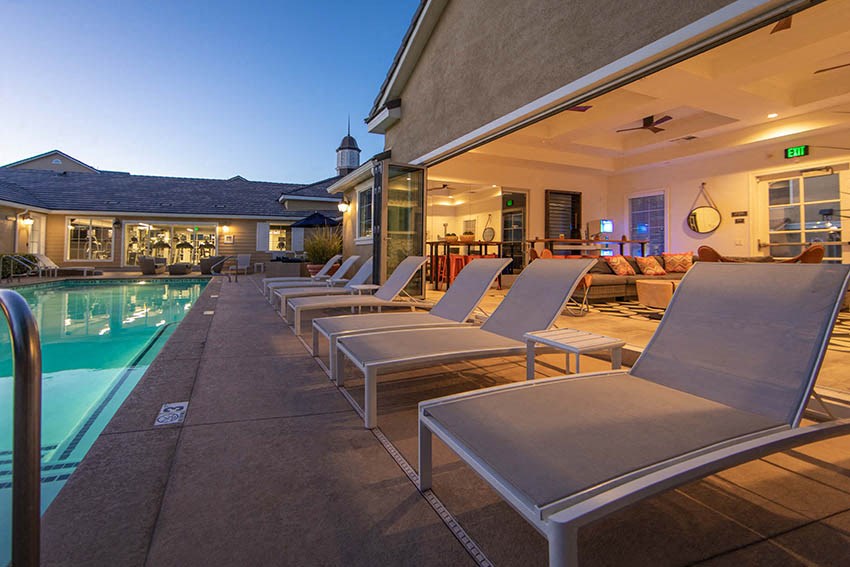 a group of lounge chairs next to a swimming pool
