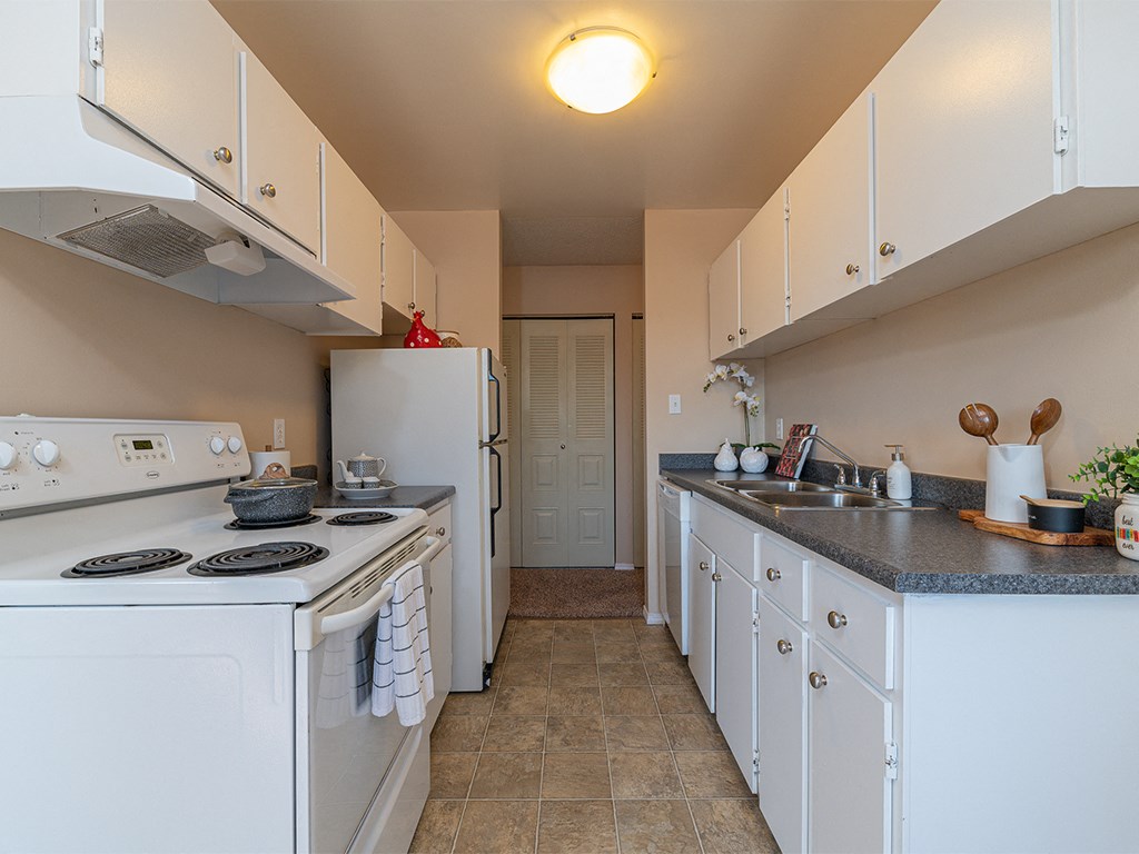a kitchen with white appliances and counters and a white refrigerator