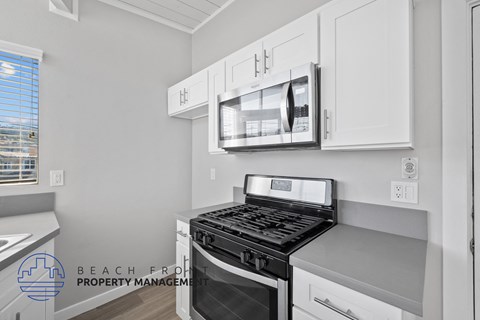 A modern kitchen with a stove top oven and microwave above it.
