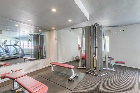 a gym with some exercise equipment and a mirror
