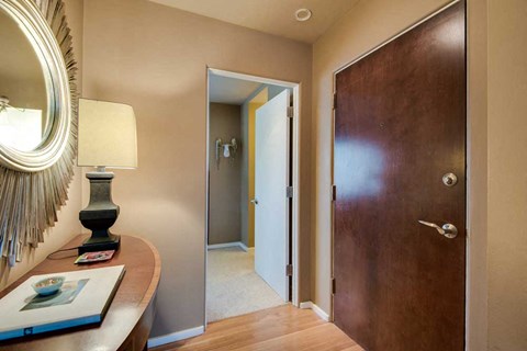 a bedroom with a wooden door and a desk with a mirror