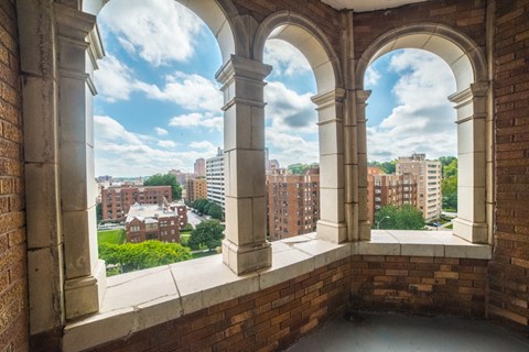 a view of the city from the balcony of a building with columns