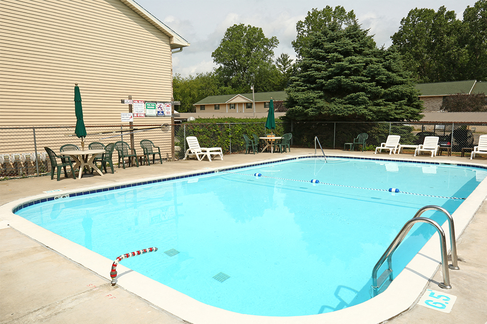 A large outdoor swimming pool with a red and white striped buoy.