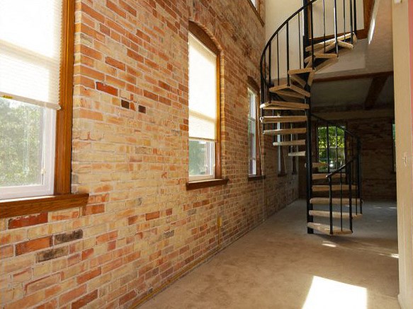 a brick wall with a spiral staircase next to it