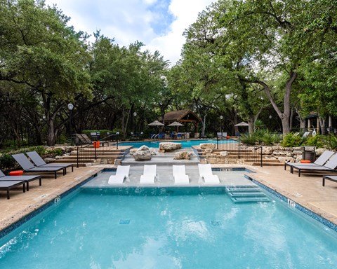 Swimming pool with built in spa and lounge seating at Nalle Woods of Westlake Apartments, Austin, TX 78746