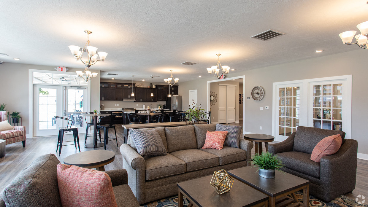 a living room with couches and chairs and a kitchen