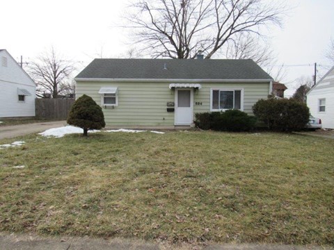 A small house with a white door and a small front yard.