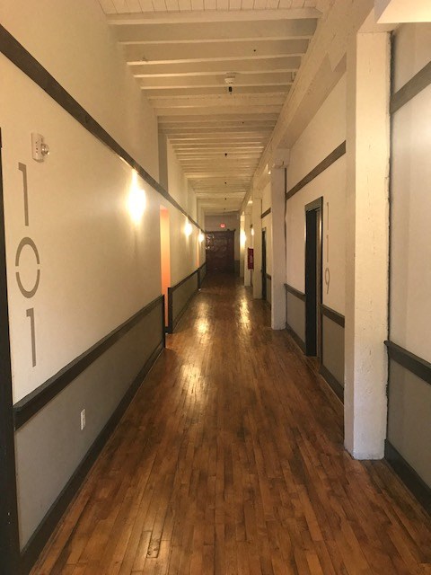a hallway in a building with wood floors and white walls