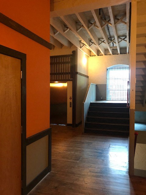 a hallway with stairs and an open door