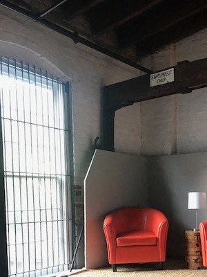 two red chairs in a room with a staircase