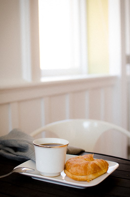 a cup of coffee and a croissant on a table