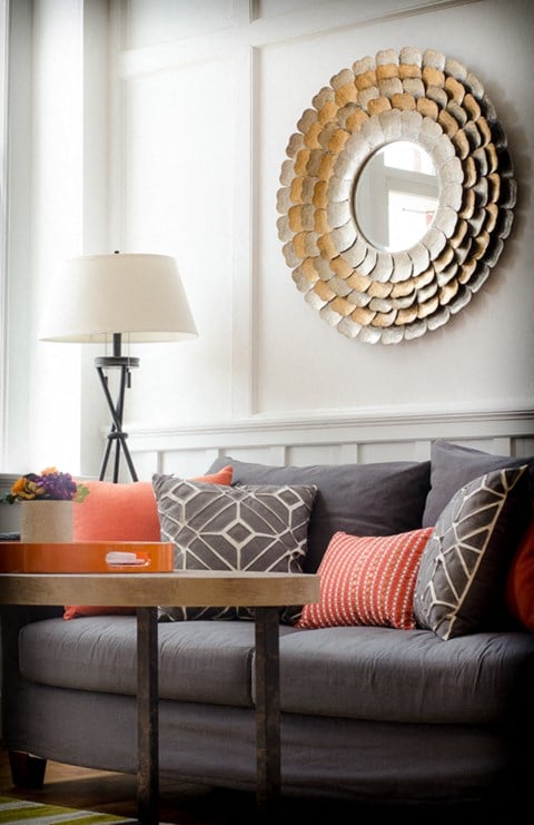 a living room with a couch and a mirror on the wall