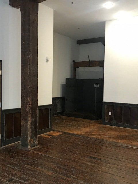 an empty room with a wooden floor and pillars