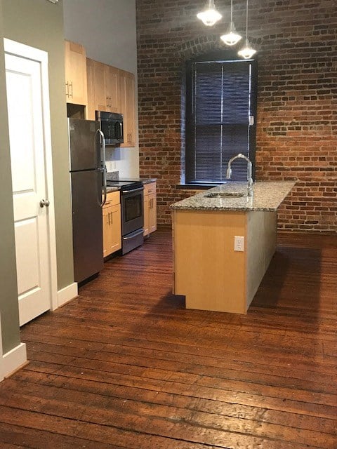an empty kitchen with a sink and a refrigerator