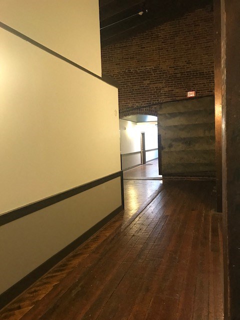 a hallway with white walls and a wood floor