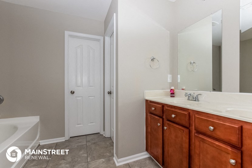 a bathroom with a sink and a mirror and a tub