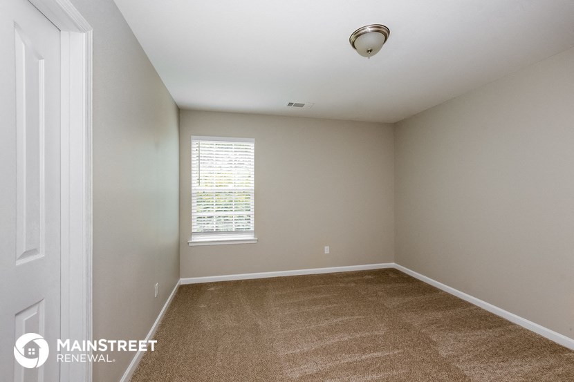 an empty room with carpet and a window