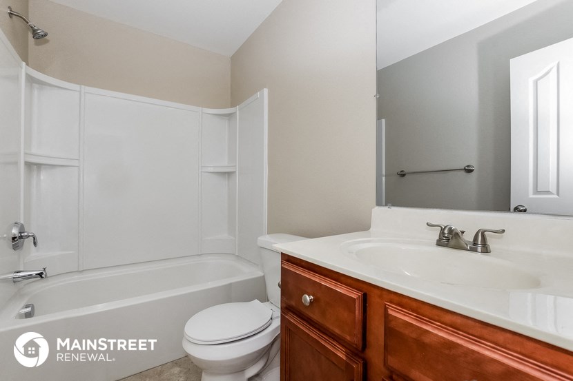 a bathroom with a sink toilet and tub and a mirror