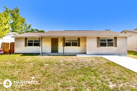 the front of a white house with a grassy yard