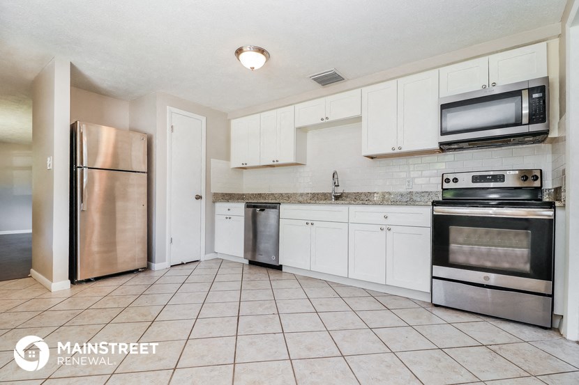 a kitchen with white cabinets and stainless steel appliances