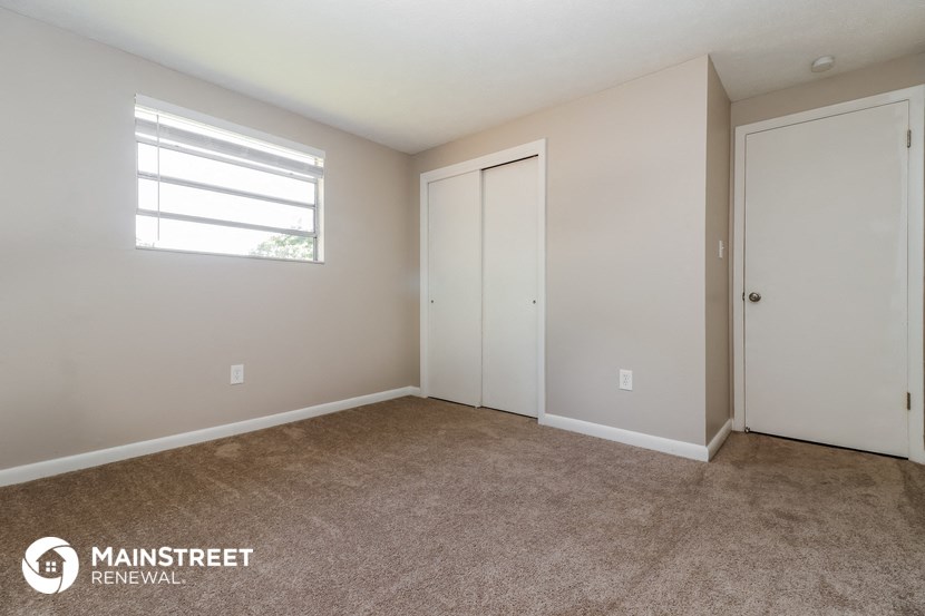 a bedroom with a carpeted floor and a window