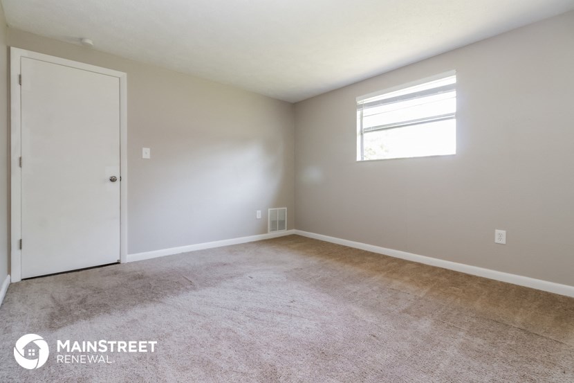 a room with carpet and a door and a window