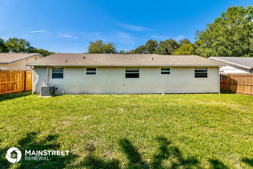 a white house with a grassy yard and a wooden fence