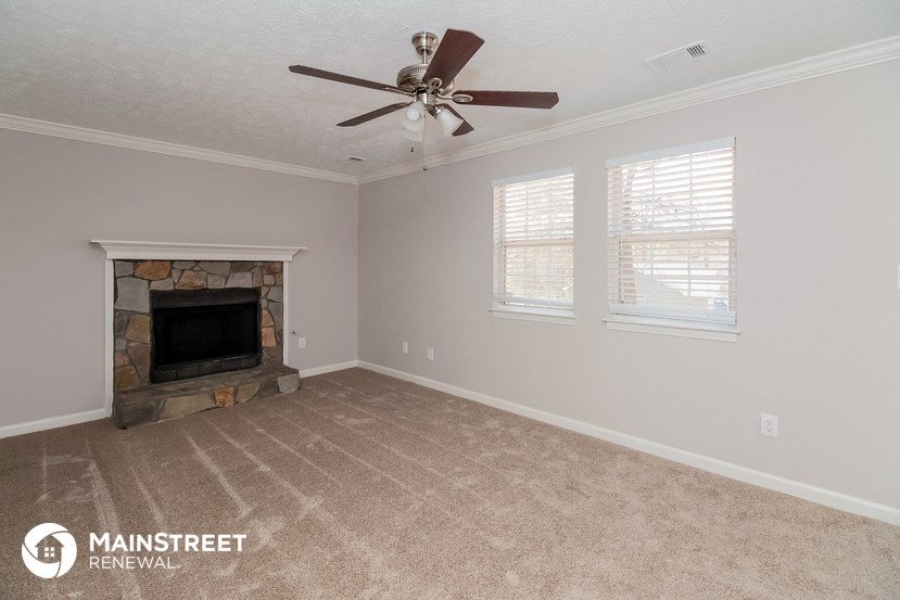 a living room with a fireplace and a ceiling fan