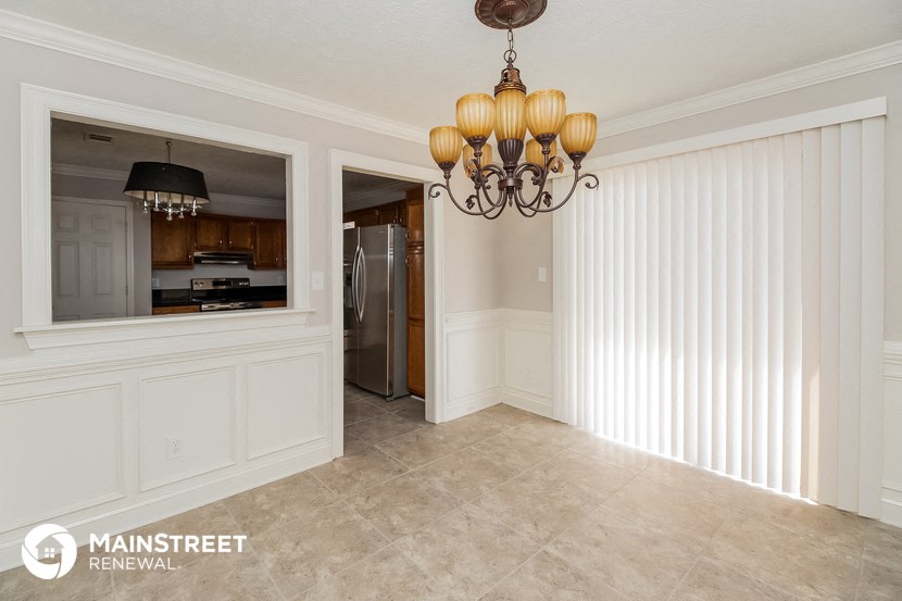 a dining room with a large window and a chandelier