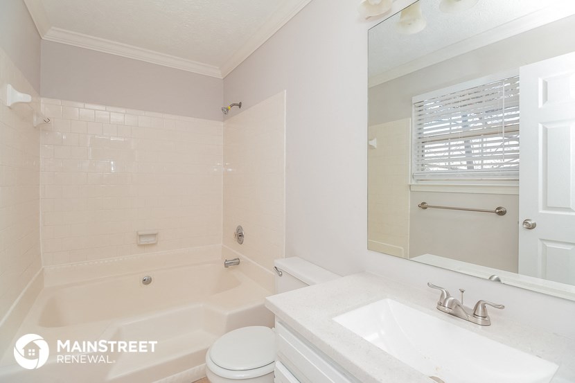 a white bathroom with a tub and a sink and a toilet