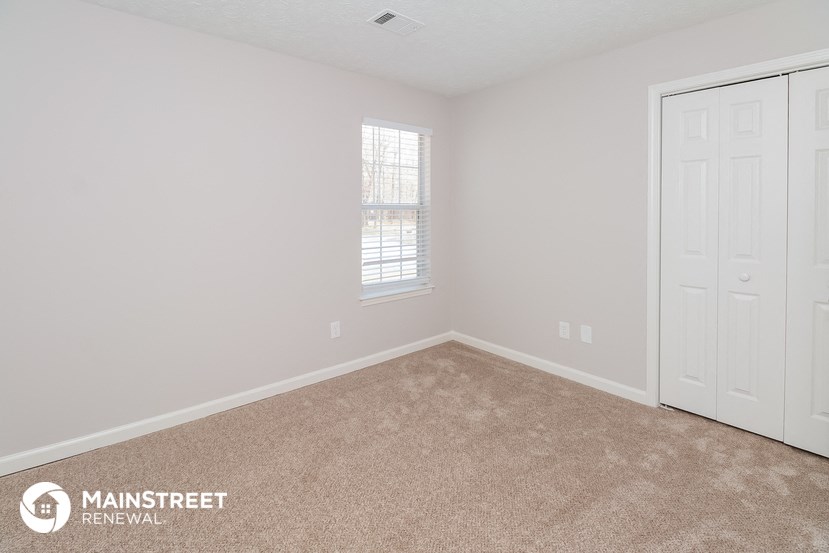 the upstairs bedroom has a carpeted floor and two closets