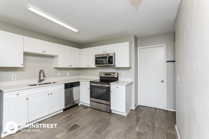 a kitchen with white cabinets and stainless steel appliances