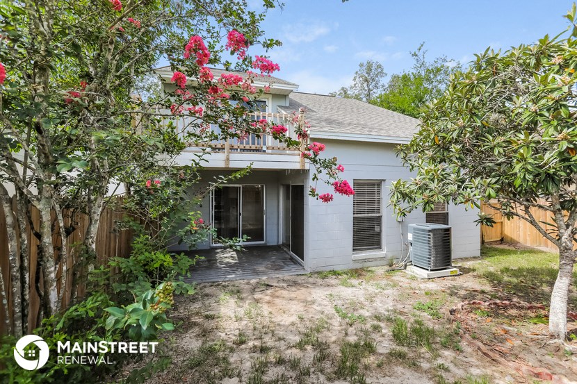 a small white house with a yard and trees