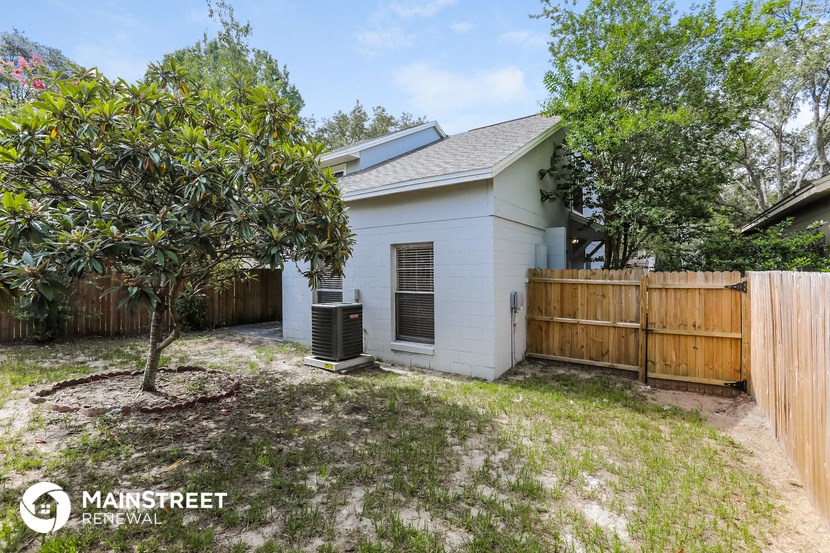 a small white house with a backyard and a fence