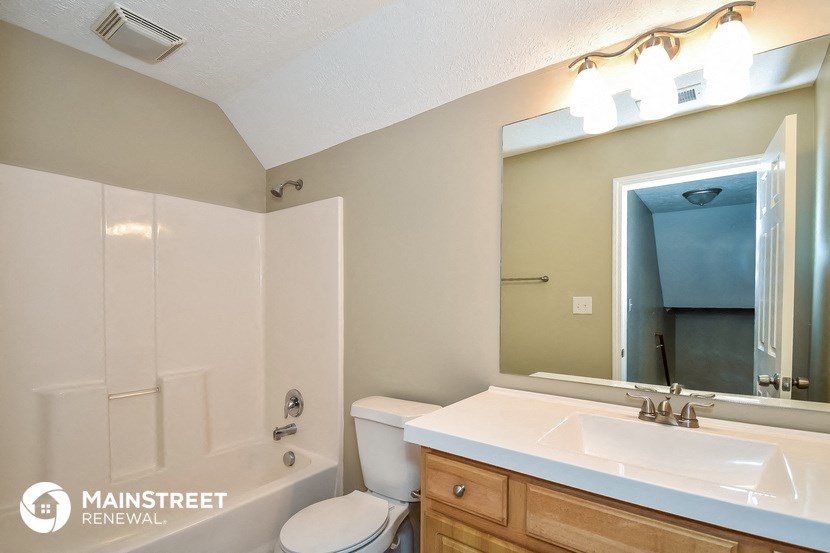 a bathroom with a sink toilet and mirror and a shower