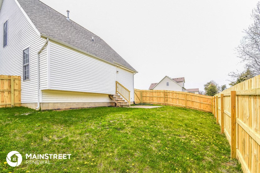 the back yard of a house with a wooden fence