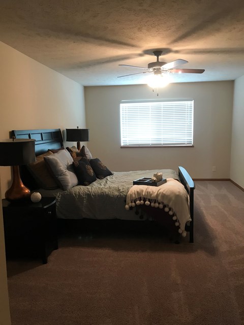 a bedroom with a bed and a ceiling fan